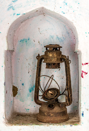Beautiful photo of an obsolete and antique kerosene oil lantern kept in a wall shelf, once widely used as a source of light in rural India and Asia, now defunct owing to development and less powercutsの写真素材