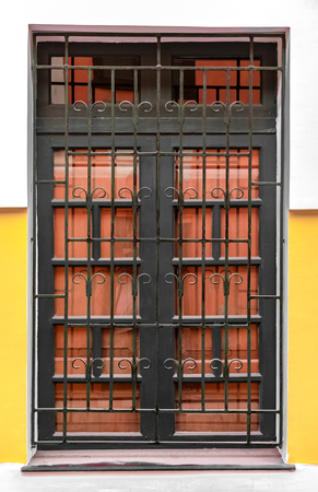 Very Beautiful Corinthian Style Big Window, having Iron Bars with patterns and Wooden Gate attached to it. A Typical Colonian Era Roman Architecture. - Imageの写真素材