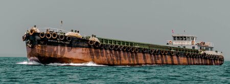 Small vessels also known locally as barges, used to feed the mother vessels, in this cases with iron ores for export, as the bigger vessel sometimes, by itself, could not be anchored at the harbor.のeditorial素材