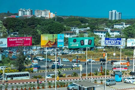 Goa, India - December 9, 2018 : Busy junction, during peak hour traffic, near Goa International Airport of Dabolim. Surrounding space being used commercially and covered with advertisement hoardingsのeditorial素材