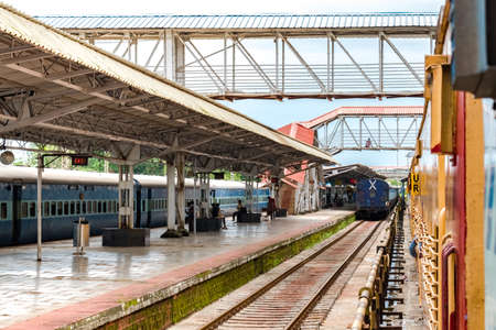 Daily Commuters and halted trains are waiting for the departure signal at Clean and less crowded Platform of Indian Railways. Footover bridge for crossing rail tracks.のeditorial素材