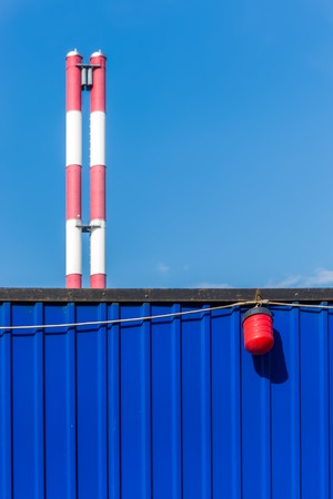 Red and white tubes and blue fence on the sky backgroundの写真素材