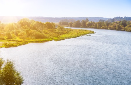 Bend of the river on sunny day with sunflare effect.の写真素材