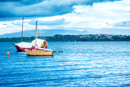 Blue ocean with boats and coastline in the distanceの写真素材