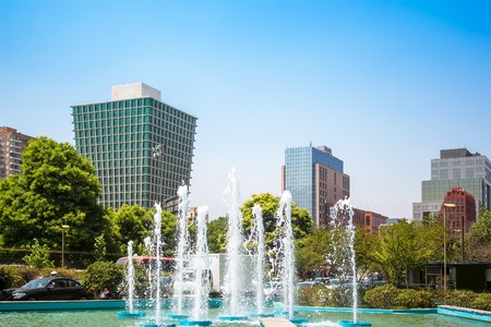 Fountain in Las Condes district with National Library on the background in Santiago, Chile
