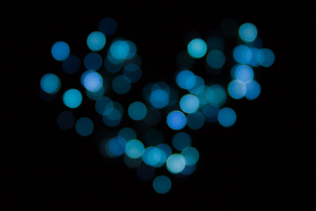 Blue heart bokeh in black backgroundの写真素材