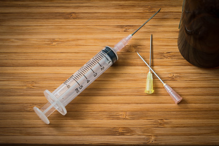 Closeup of the syringe on the wood backgroundの写真素材