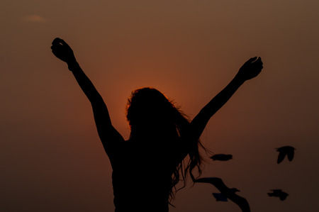 woman successfull and very happy open arms under the sunsetの写真素材
