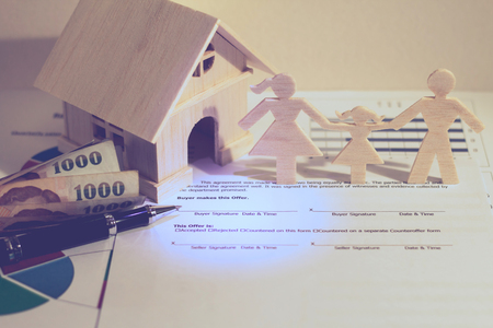 A family and home with model and money put on the agreement, Business investment loan for real estate or saving for buy new house in the future concept.の写真素材