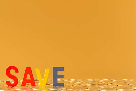 Wooden alphabet save put on the stacking gold coins in the office, Saving money for future investment concept.の写真素材