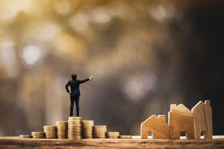 Businessman standing on stack gold coin with grow value with working capital management and home...