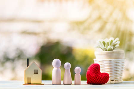 Family wood and and red heart and house model on sunlight in the public park, Loan for business investment real estate or saving money for buy home to one's love concept.の写真素材