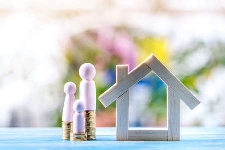 Family put on the gold coin with growing value of interest and wooden home model put on the vintage...