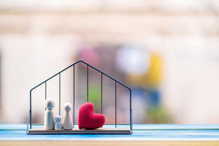 Family wood and red heart put in the house model on sunlight in the public park, Loan for business investment real estate or saving money for buy home to one's love concept.の写真素材