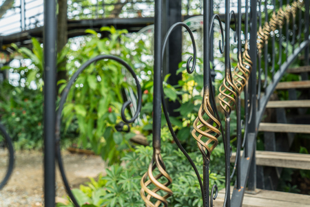 Vintage wrought iron staircase with wooden handrails and stepsの写真素材