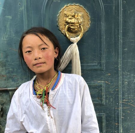 July 21,2018 Gansu,China Tibetan children are standig on the door and looking at cameras in the provinces countrysideのeditorial素材