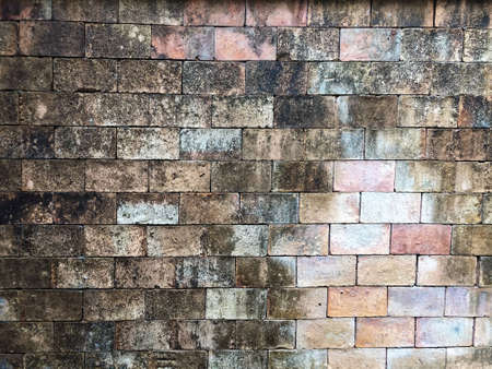 old weathered exposed and moldy  brick wall background,Background of brick wall torn apart by time. Old wall of different colorsの写真素材