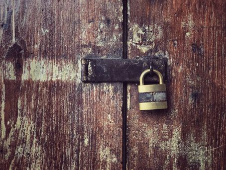 antique wooden door locked with old keypad background and textureの写真素材