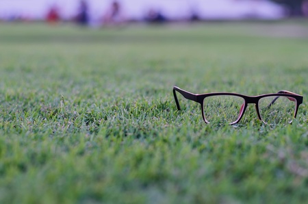 Eyeglasses on grass at background blur, can be used as a backgroundの写真素材