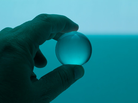 Holding Glass Ball in Blue Greenの写真素材