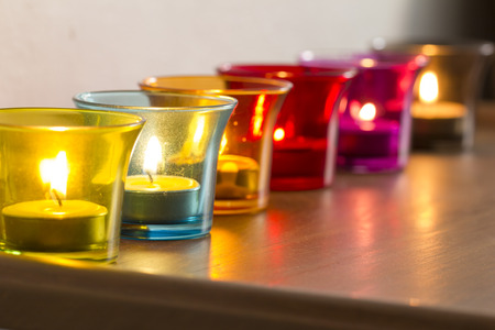 Candle in Colorful Glass on Wooden tableの写真素材