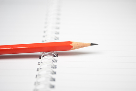 Red Pencil on Notebook with Blur backgroundの写真素材