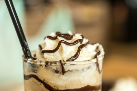 Whipped cream coco milk shake in tall glass with blur backgroundの写真素材