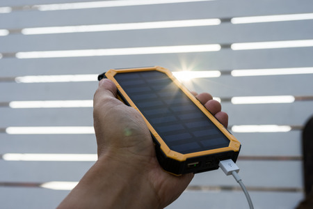 Technology Yellow Solar Cell Smartphone Charger Laydown on Wooden table in Day light Close upの写真素材