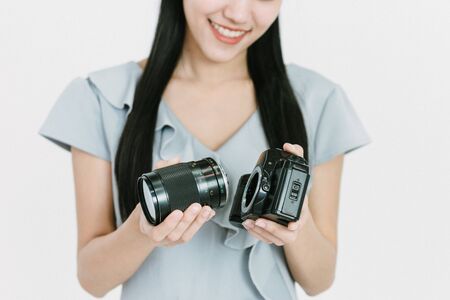 Thai Woman removing lens from cameraの写真素材