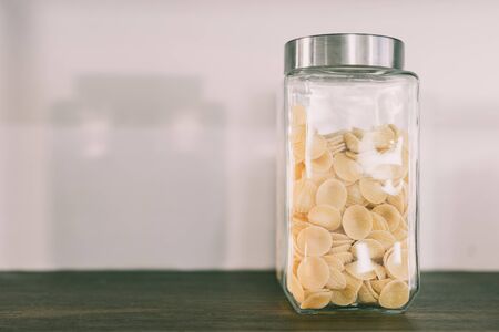 Dried Pasta in Vacuum Glass Jar on Shelf on the Right in Vintage tone Close-upの写真素材
