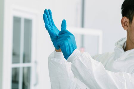 Lab Technician in Personal protective equipment  PPE suit Vaccines testing of Virus wearing disposable rubber glovesの写真素材