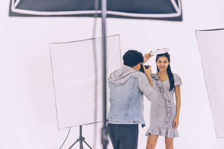 Asian Photographer shooting with Asian female model in Studio with studio strobeの写真素材