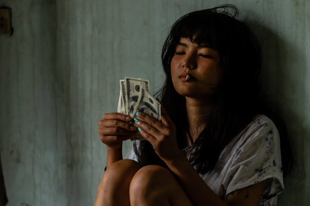Asian women smoking and counting dollar bills In her hand there is a banknote. In a scary atmosphere, illegal, dangerous, risk death, Concept of dirty societyの写真素材