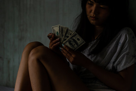Asian women smoking and counting dollar bills In her hand there is a banknote. In a scary atmosphere, illegal, dangerous, risk death, Concept of dirty societyの写真素材