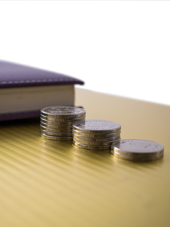 Thai Baht coin step on golden background and purple bookの写真素材
