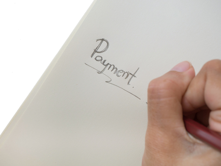 Asian female hand with pencil writing on yellow notebook isolated on white backgroundの写真素材