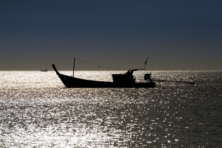 Silhouette Boat in the Seaの写真素材