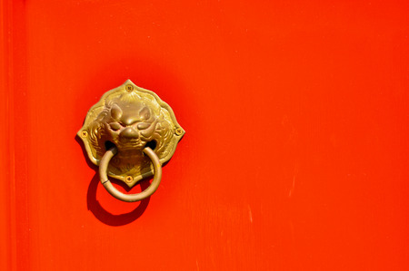 Asian Lion Door Knocker on Red Backgroundの写真素材