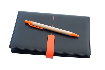 Black leather notebook and pen isolated on whiteの写真素材