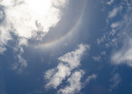 Sun halo with blue sky and cloudsの写真素材