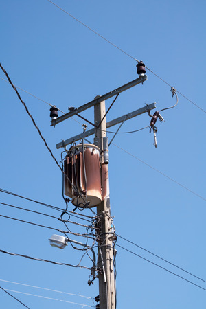 Old transformers of an electrical post with power-linesの写真素材