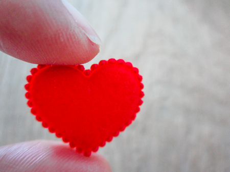 Red heart holding by figuresの写真素材