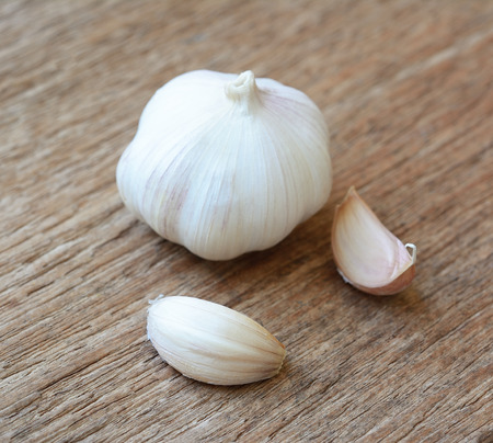 Organic garlic whole and cloves on the wooden background