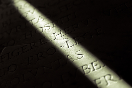 Narrow beam of light on a stone with inscriptionsの写真素材
