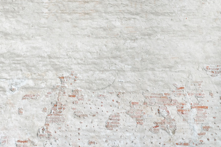 Brown brick wall behind white stucco, background, textureの写真素材
