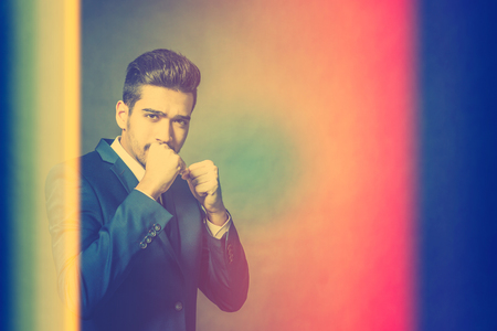 Young attractive man in a blue suit standing in a fighting stance. Tonedの写真素材