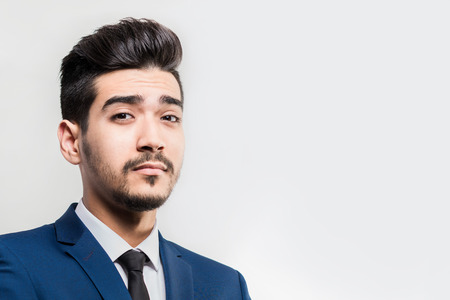Young attractive man in a blue suit on a gray background. Isolatedの写真素材