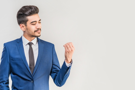 Young attractive man in a blue suit on a gray background. Isolatedの写真素材