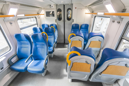 Interior of the speed commuter train with empty blue seatsの写真素材
