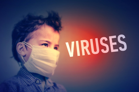 Boy in the medical mask covered his face with his hands next to inscription VIRUSES